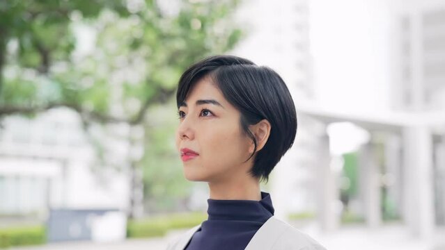 街中で空を見上げる女性