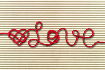 Colored rope in heart shape knot on background. Love concept.