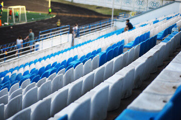 Fototapeta premium Plastic chairs in the stands of a sports stadium. Cheer on the stands of the stadium.