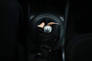 Hand on the car gear knob. The driver switches the speed in the car. Hand on gear lever.