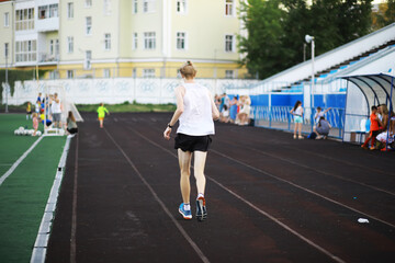 The child goes in for sports at the stadium. The boy is training before playing football.