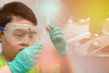 child use dropper in tube for education in learning laboratory and research with fun in chemical technology and biology like scientist