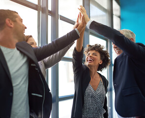 Positivity breeds success. Shot of a group of colleagues giving each other a high five.