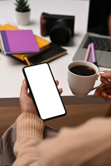 Obraz premium Close up view businesswoman drinking coffee and checking social media on smart phone.