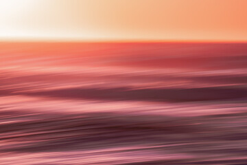 Red sunset. Seascape with blur panning motion. Sunrise or sunset over sea, beautiful soft light red...