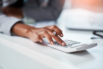 Know your numbers, know your business. Cropped shot of a businesswoman using a calculator at her...