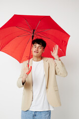 A young man holding an umbrella in the hands of posing fashion light background unaltered