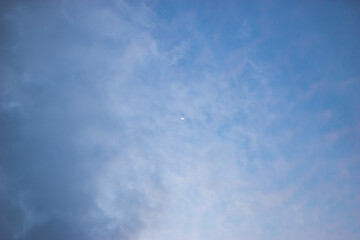 Blue sky with light clouds and moon. Beautiful sky. Scenic view in evening