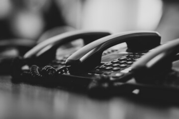 Shallow depth of field (selective focus) details with analogue telephones with secure connections in a high security public institution. - obrazy, fototapety, plakaty