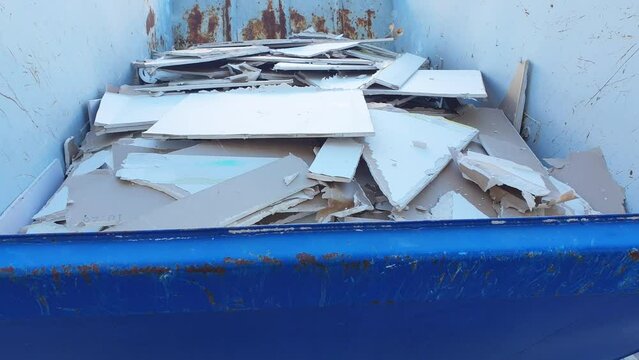 Blue metal container with plasterboard debris