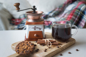 Two cups of coffee, coffee pot, coffee grinder, saucer with cookies and chocolates on wooden texture