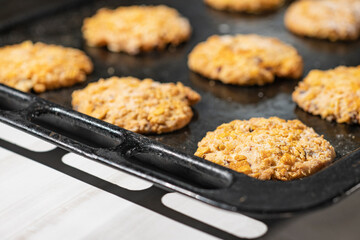 Homemade cookies with chocolate, nuts on an iron baking sheet and an artphone in the morning. Close up. Breakfast.