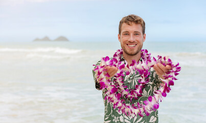 Hawaii welcome caucasian man in hawaiian shirt welcoming tourist giving lei of fresh flowers as...