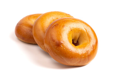 A Row of Three Plain Bagels Isolated on a White Background