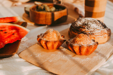 Picnic on a white plaid with pillows, tablecloth, fruits, drinks and accessories, top view