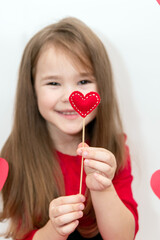 A heart on a stick in the hands of a childs girl. Concept Valentines Day and Children.