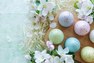 Easter eggs in wooden tray on green wooden background