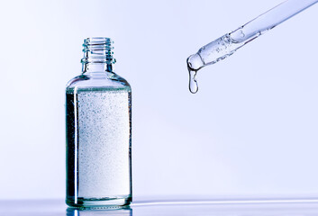 bottle of serum with a pipette on a light background	
