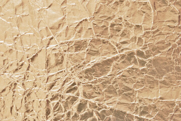 A sheet of wrinkled golden foil texture as background	