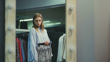 A pretty girl tries on clothes in a clothing store. Shopping