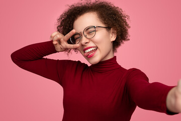 Happy woman showing tongue and taking selfie