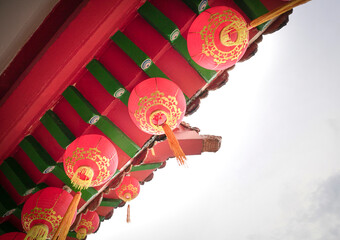 Hanging red lanterns on temple roof. Low angle view, copy space.