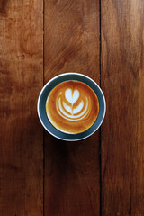 a cup of latte art coffee on wooden background                                                                                                                                                          