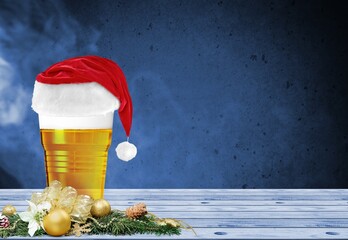 Glass of beer Christmas in Santa's red hat, wooden desk