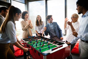 Business people having great time together.Colleagues playing table football in modern office