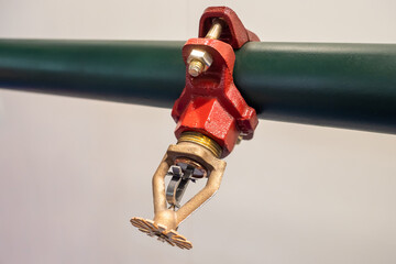 Automatic sprinkler in fire extinguishing system. Automatic sprinkler on black pipe. Close-up of mechanism for extinguishing fire. Sprinkler fire extinguishing system. Automatic anti flame system - obrazy, fototapety, plakaty