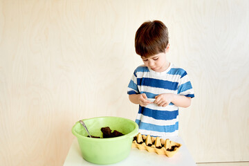 A little boy is planting seeds for seedlings.Life hack for gardeners. An interesting activity and a useful hobby for child. Preschool education. Human and nature. Growing plants. Farming. Copy space.