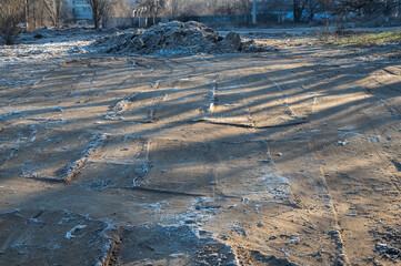 Frozen ground leveled by a bulldozer. The top layer of soil is covered with frost. Construction site, industry.