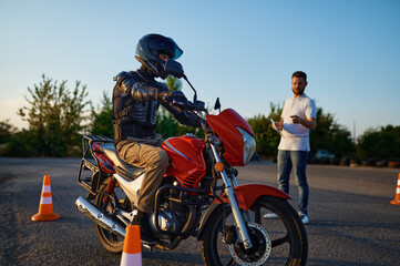 Fototapeta na wymiar Riding between cones, lesson in motorcycle school