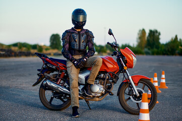 Fototapeta na wymiar Male student poses on motorbike, motorcycle school