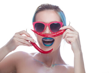 Portrait of Laughing Caucasian Girl Wearing Teeth Braces Having Fun With Red Pepper Against White.