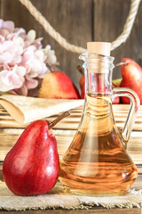 Food, vegetarianism, healthy diet food, drink. Natural juice without pulp from fresh red pear in a glass decanter, wine, liqueur and seasonal fruit harvest in a wooden box on the table