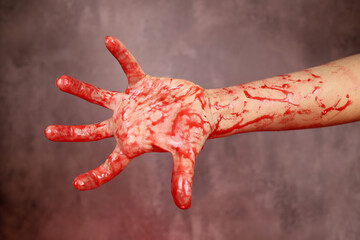 Bloody hand of the victim of a maniac, a murderer on a gray background