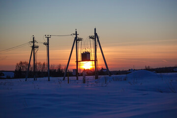 Transformer substation against the backdrop of a beautiful sunset sky. high voltage wires at dusk. power plant at sunset