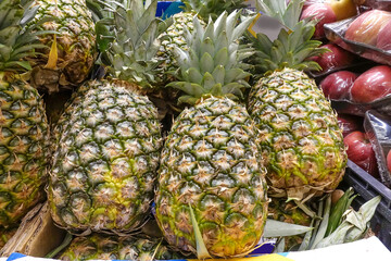 A group of pineapples in a tray at the market. Sale of fruits in the store