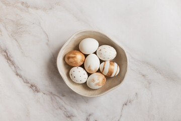 Easter layout. Organic colored painted Easter eggs in handicraft ceramic bowl. Simple composition, selective focus