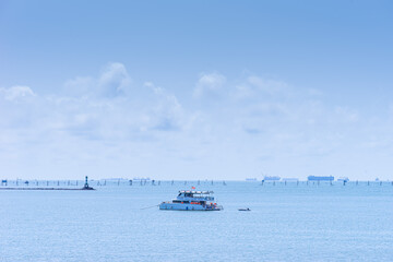 A white yacht moored in the sea near Vung Tau city with blue sky in background