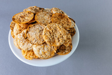 Brown rice chips on a gray background