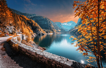Impressive Autumn landscape during sunset. The Alpine Lake in front of the snowy mountain under...