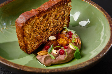 Chicken liver pate with artisan bread in green handmade ceramic plate. Appetizer from liver with...