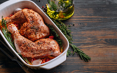 raw turkey chicken thighs rubbed with spices and salt, on a baking sheet, with oranges lemons garlic rosemary thyme and olive oil. the concept of a healthy and tasty dinner for two.