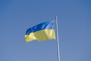 Huge Ukrainian flag waving against a clear blue sky