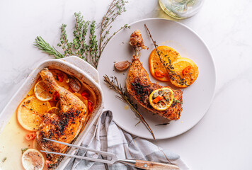 roasted fried turkey duck thighs, rubbed with spices and salt, on a baking sheet, with oranges,...