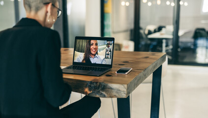 Fototapeta na wymiar Modern businesswoman attending a video conference with her global partners