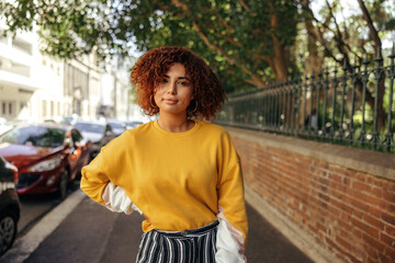 Carefree teenage girl standing on a sidewalk