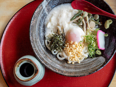 Japanese bukkake udon bowl over red tray
